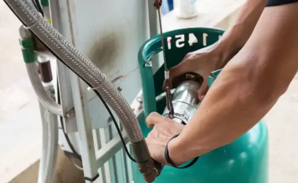 A man filling a propane tank.